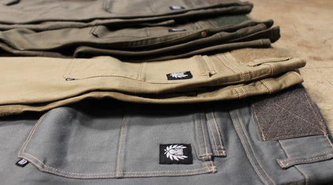 Carlos Ray tactical pants in four different colors folded over and spread toward the background